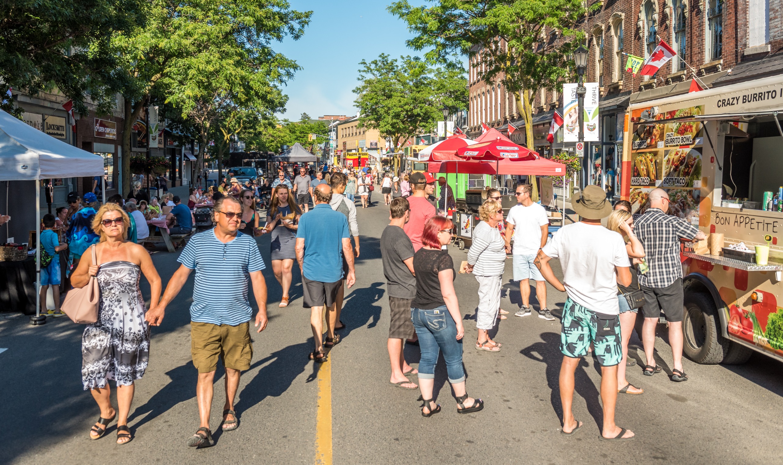 Crowd of people explore vendors and food stalls on King Street, downtown Cobourg.
