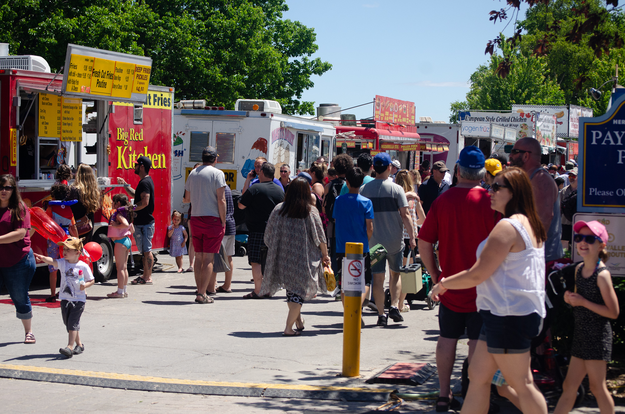 Crowds of people explore food trucks and vendors at the Cobourg Waterfront Festival