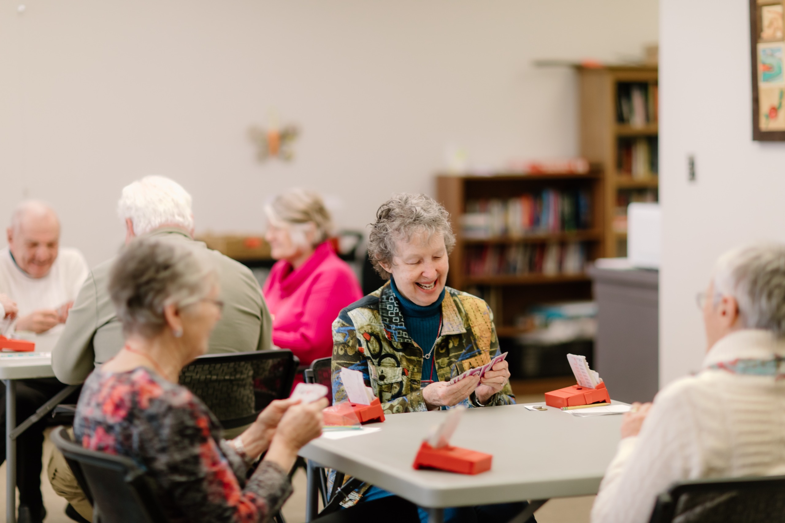 Seniors sitting at table playing a card game
